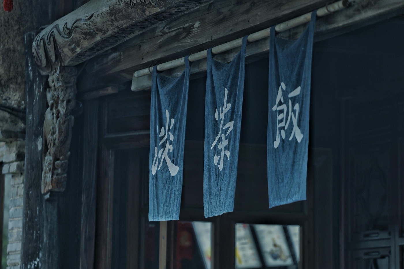 Indigo cloth door curtains hanging outside an old wooden shopfront